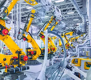 Industrial robotic arms in an automotive manufacturing facility