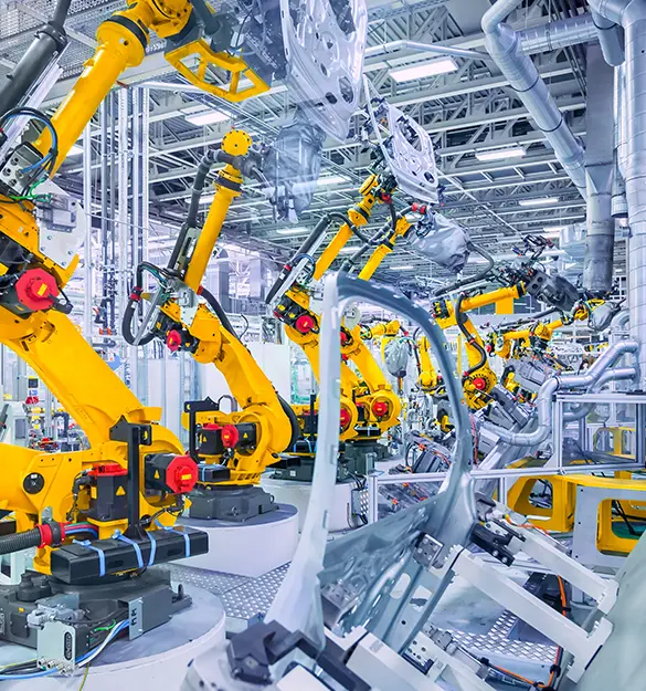 Industrial robotic arms in an automotive manufacturing facility